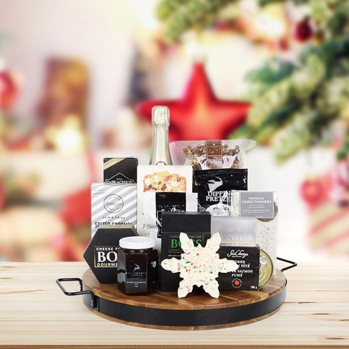 Winter Wonderland Gift Board with Champagne Seachange, CaPaechio’s water crackers, cherry almond toast for cheese, Boss Gourmet Cheese, Hollyberry marshmallow & chocolate popcorn, a bar of white chocolate with Oreo chunks, East Shore Dipping Pretzels, chocolate truffles from Monarch, smooth dark chocolate box, Simply Naked sea salt pistachios, Hollyberry cranberry raspberry jam, a snowflake shaped peppermint bark, and Cookie It Up salted caramel crunch cookies